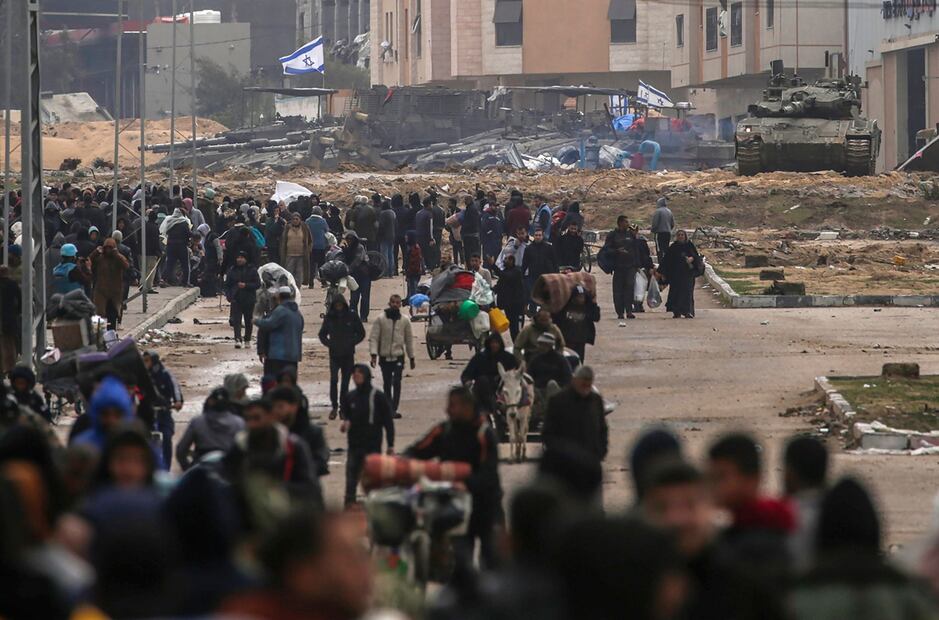Los palestinos desplazados internos pasan junto a los tanques israelíes después de que el ejército israelí dijera a los residentes del campamento de Khan Yunis que abandonaran sus hogares y se dirigieran a los campamentos de Rafah, cerca de la frontera con Egipto, en el sur de la Franja de Gaza. Foto: EFE