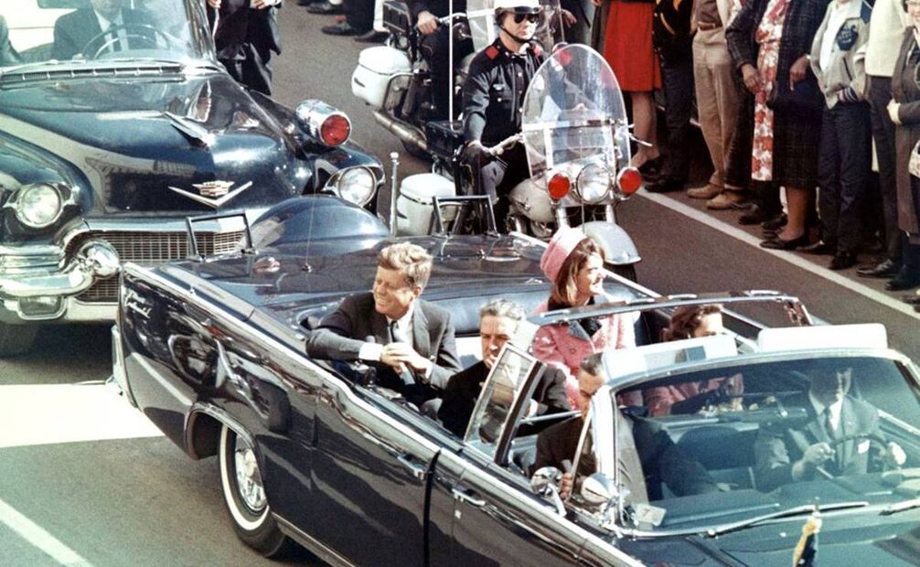 John F. Kennedy y su esposa, Jacky" Kennedy en el asiento trasero de la limousina presidencial. Frente a ellos iban el gobernador texano John Conally y su esposa, y al volante dos agentes. Wikimedia Commons.