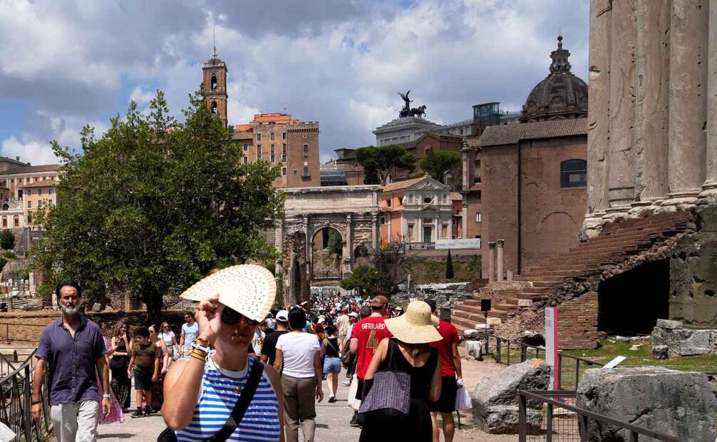 Touristas emplean abanicos y sombreros para protegerse del calor durante una visita al Foro de Roma, el 22 de julio de 2025. Foto: AP