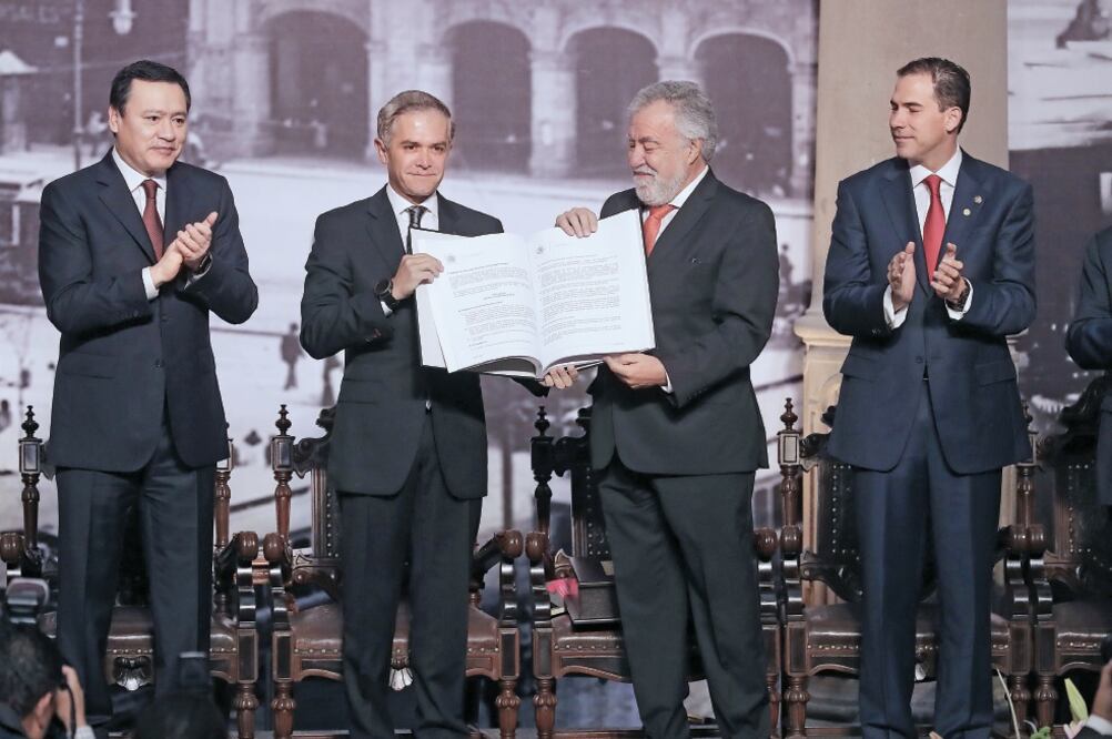 Miguel Ángel Mancera, jefe de Gobierno de la Ciudad de México, y Alejandro Encinas, quien presidió la Mesa Directiva de la Asamblea Constituyente, sostienen el texto constitucional (ALEJANDRO ACOSTA. EL UNIVERSAL)