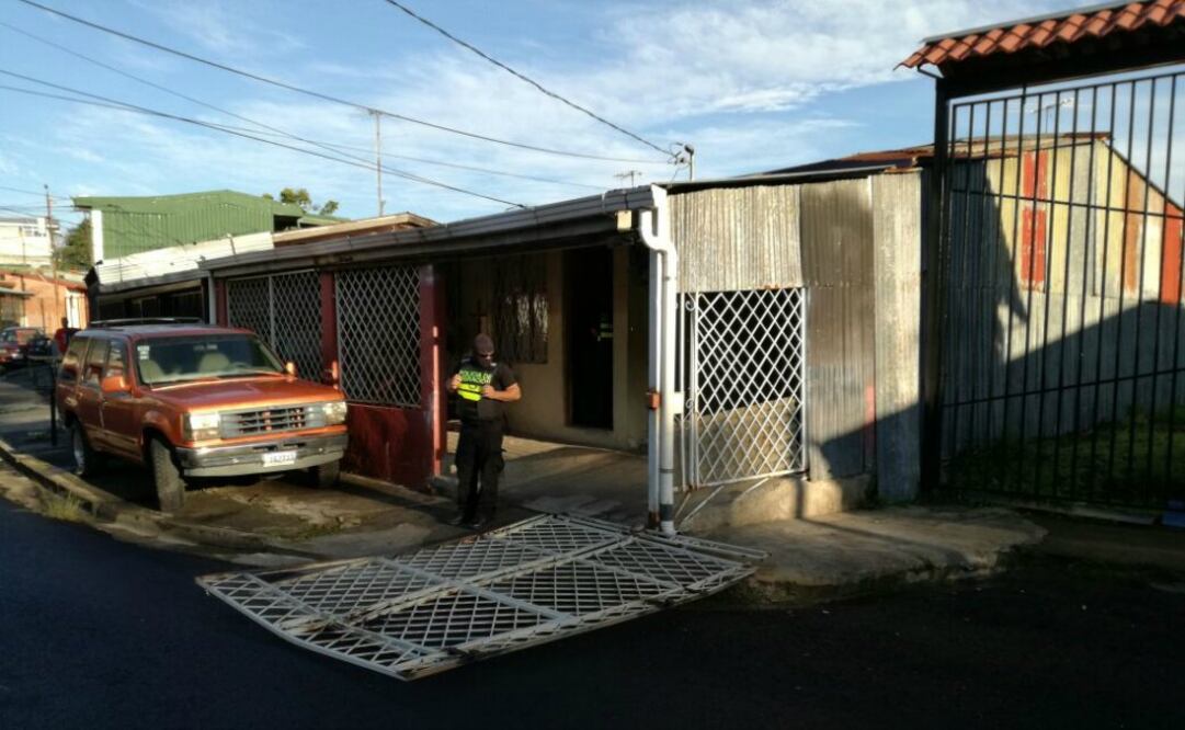 Un policía custodia a la entrada de una de las casas que fueron allanadas para desarticular una red de contrabando de cubanos de Ecuador y Perú a México. Foto: Dirección General de Migración de Costa Rica