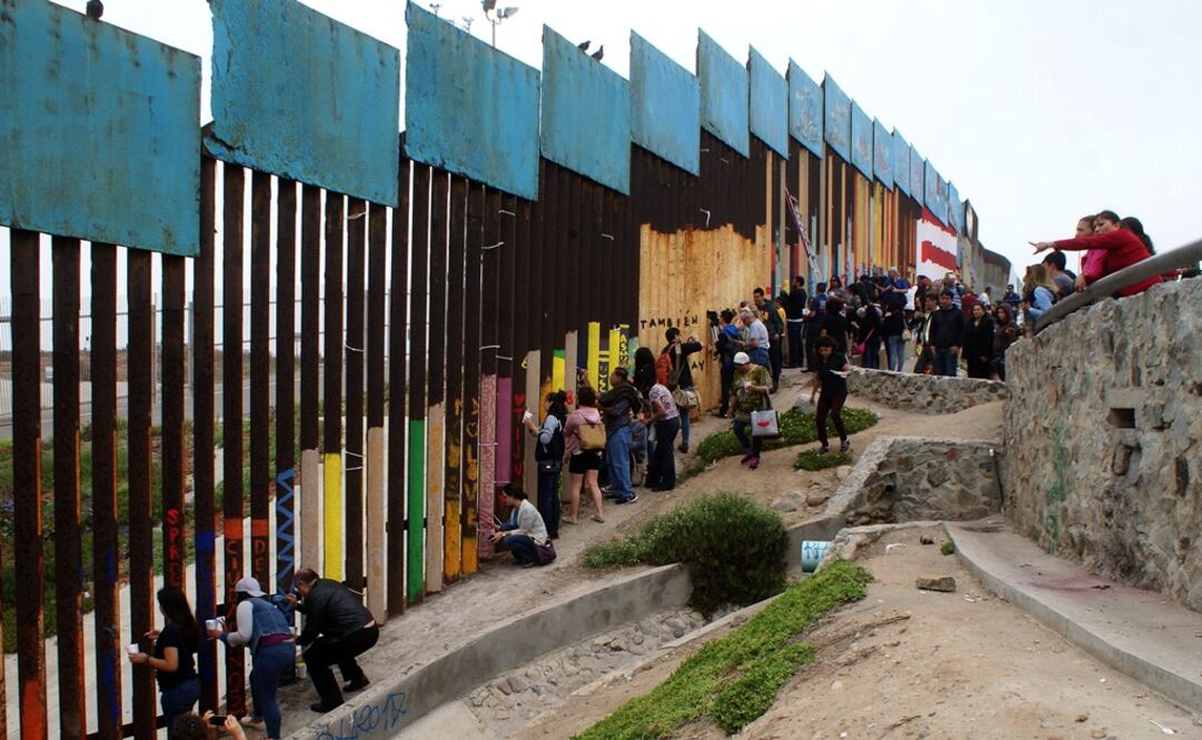 Ciudadanos mexicanos pintan el muro fronterizo entre México y Estados Unidos. Foto: EFE