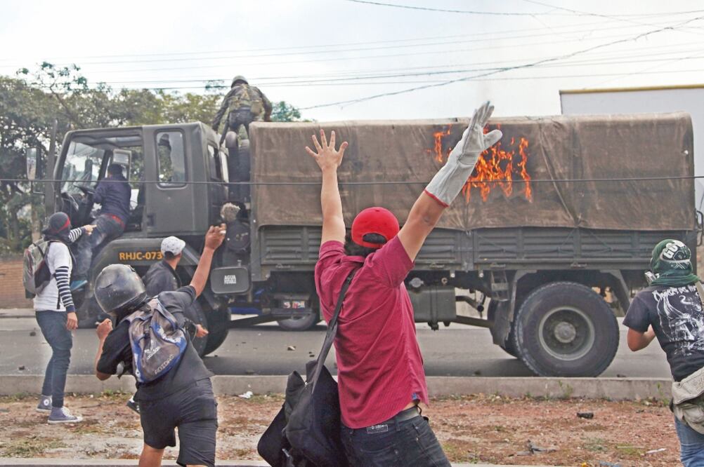 Un soldado y un conductor abandonaron su vehículo luego de que los manifestantes lo incendiaran en Tegucigalpa (FERNANDO ANTONIO. AP)