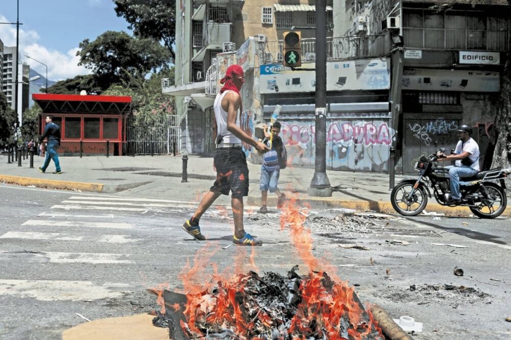 Un manifestante bloquea una calle de Caracas durante una movilización realizada ayer contra la Asamblea Constituyente y el gobierno de Nicolás Maduro. (MARCO BELLO. REUTERS)