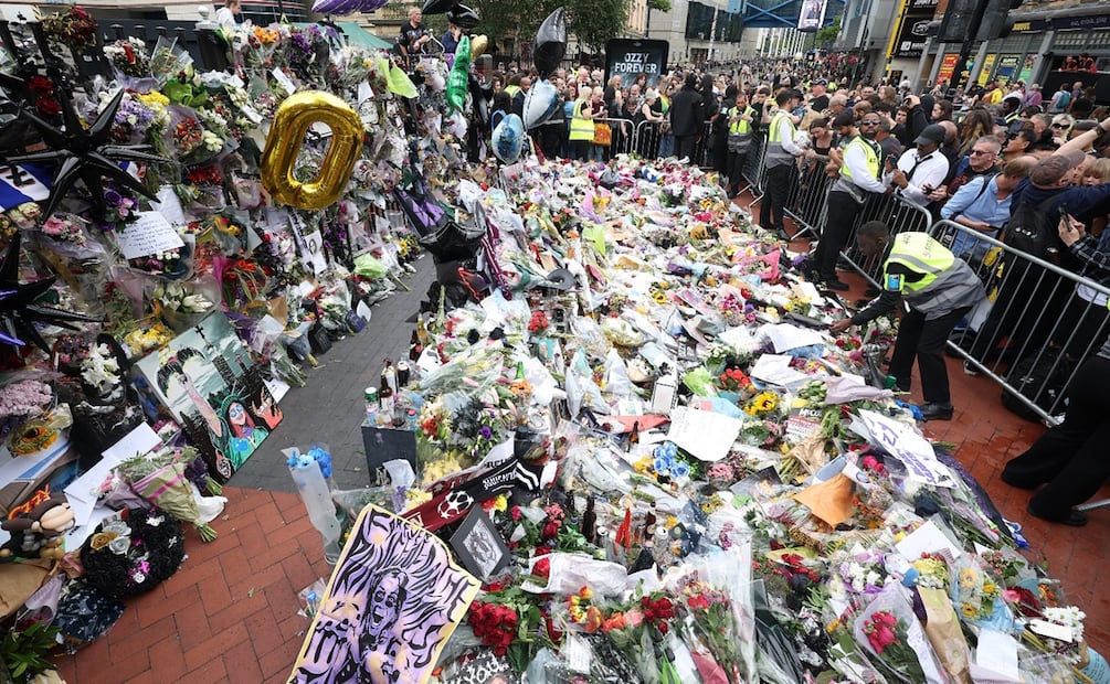 Los fans se congregan alrededor del banco y el puente de Black Sabbath para fotografiar los homenajes a Ozzy Osbourne tras presenciar su cortejo fúnebre en Birmingham, Reino Unido. Foto: EFE/EPA/ADAM VAUGHAN.