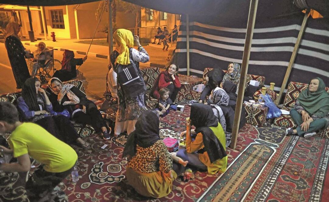 Refugiados de Afganistán se reúnen bajo una tienda de campaña beduina fuera de un complejo de villas construido para albergar a los invitados de la Copa Mundial de la FIFA 2022, en Qatar. Foto: Marwan Tahtah/ AFP.