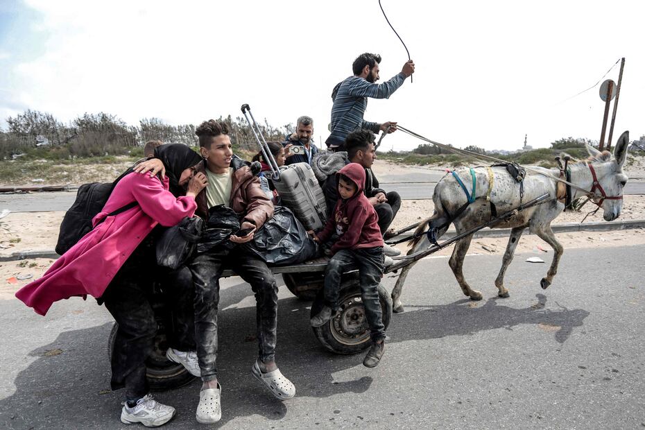 Palestinos desplazados que huyen de la zona cercana al hospital al-Shifa de la ciudad de Gaza viajan en un carro tirado por burros cuando llegan al campo de refugiados de Nuseirat en el centro de la Franja de Gaza el 18 de marzo de 2024. Foto: AFP