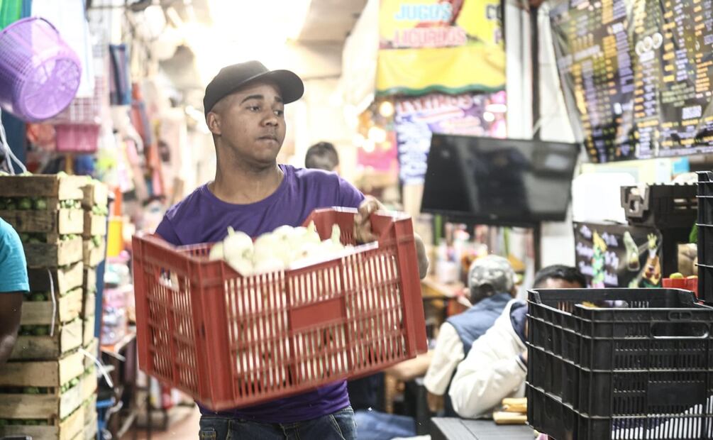 Dairon, de Cuba, y Francis,de República Dominicana, son dos migrantes que trabajan en el Mercado Nezahualcoyotl. Foto: Gabriel Pano El Universal