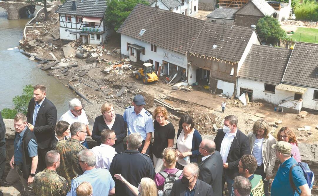La canciller alemana, Angela Merkel (atrás, tercera a la izq.), ayer en el pueblo de Schuld, destruido por la crecida del río Ahr. Foto: Cristof Stache/ AP.