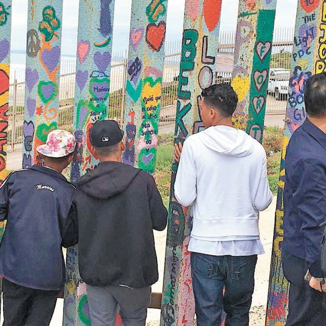 Entre las rendijas de la valla de cuatro metros de altura, los migrantes empuja n sus rostros como si quisieran atravesarla para pisar tierra estadounidense. GABRIELA MARTÍNEZ. EL UNIVERSAL