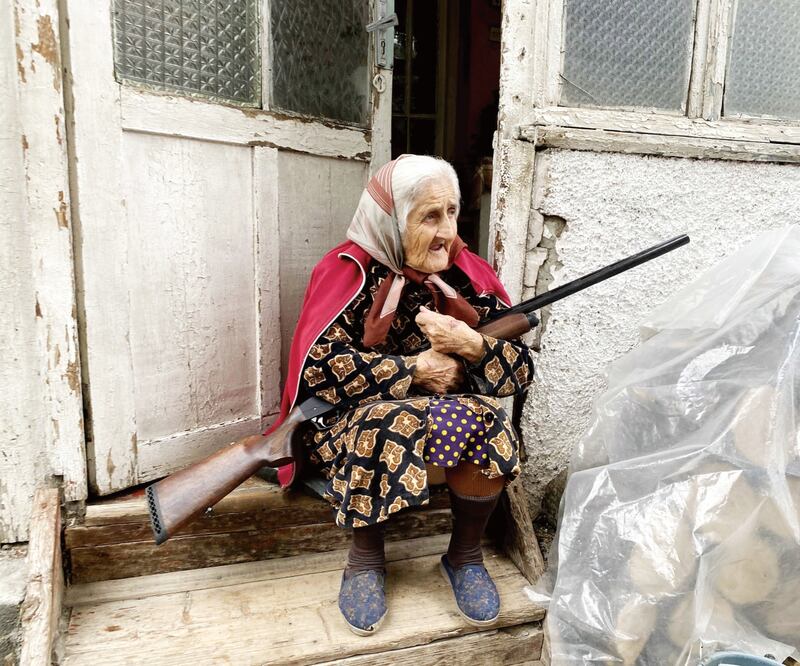 Una mujer adulta, cargando una escopeta a fuera de su casa en Stepanakert. Pablo González. EFE