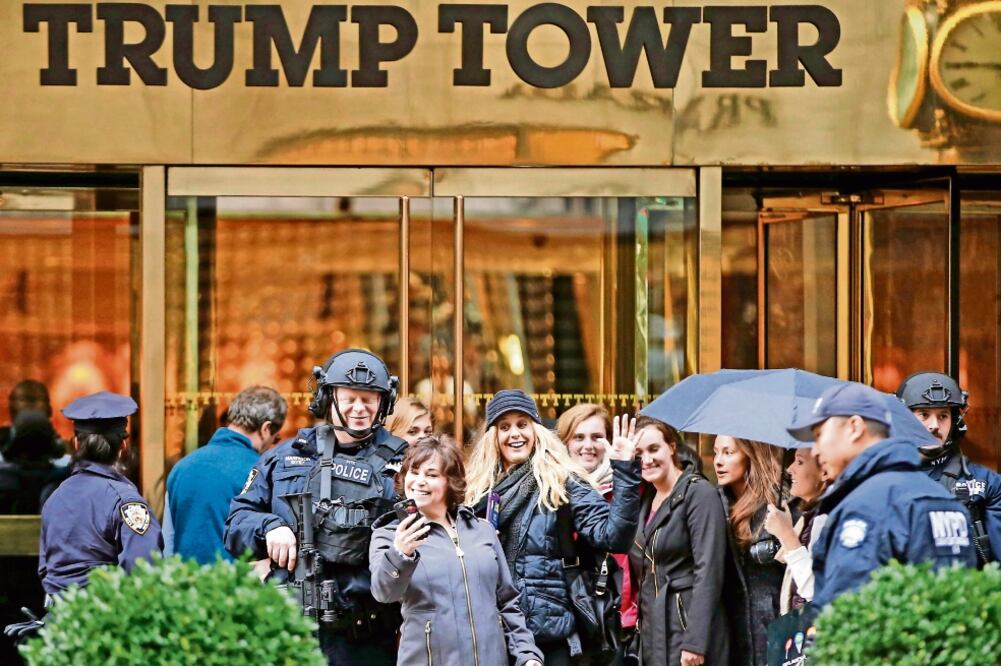 Turistas se toman una selfie frente a la Trump Tower; el lugar ha ganado popularidad tras el triunfo del republicano (KATHY WILLENS. AP)