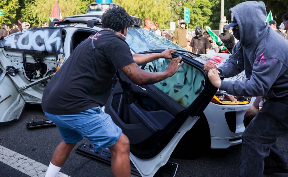 Manifestantes vandalizan un coche autónomo de Waymo durante las protestas contra las redadas de inmigración en Los Ángeles, California, EE.UU., el 8 de junio de 2025. Foto: EFE/EPA/ALLISON DINNER