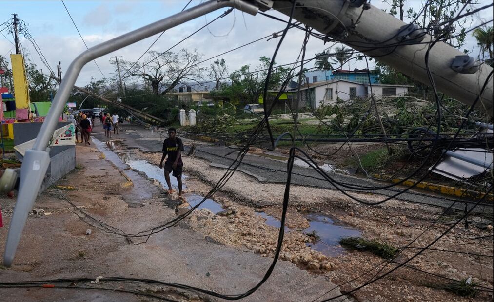 Residentes caminan por Santa Cruz, Jamaica, en donde el huracán Melisa dejó postes y árboles caídos, el miércoles 29 de octubre de 2025. Foto: AP