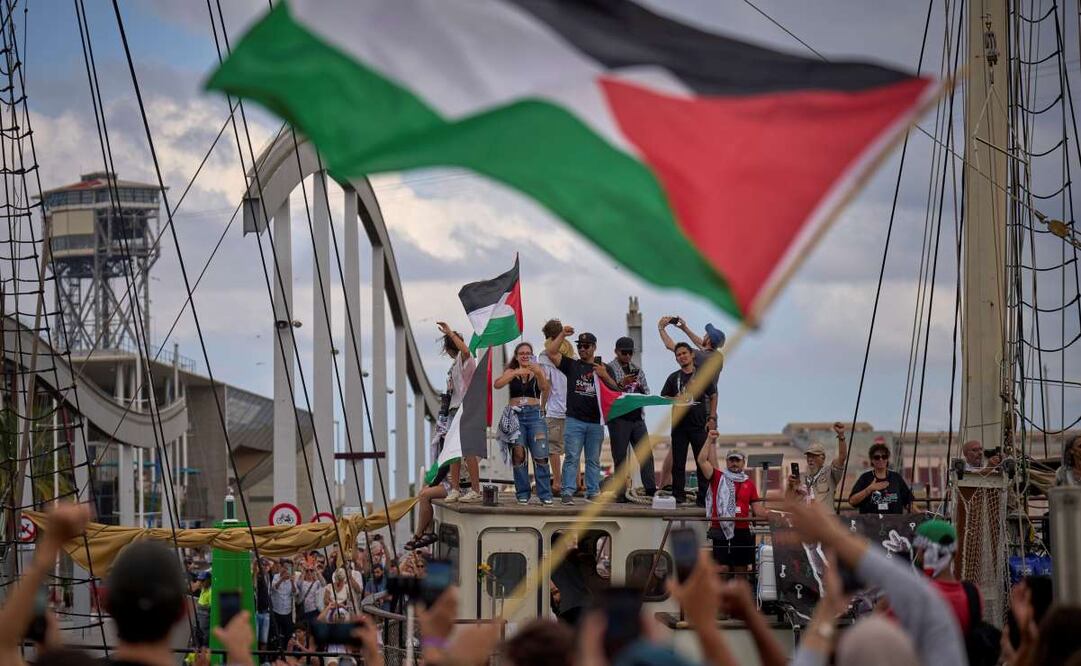 Activistas saludan el domingo 31 de agosto de 2025 desde un barco en Barcelona, España, que participa en una flotilla civil con destino a Gaza con el objetivo de romper el bloqueo israelí y entregar ayuda humanitaria en el territorio palestino. Foto: AP