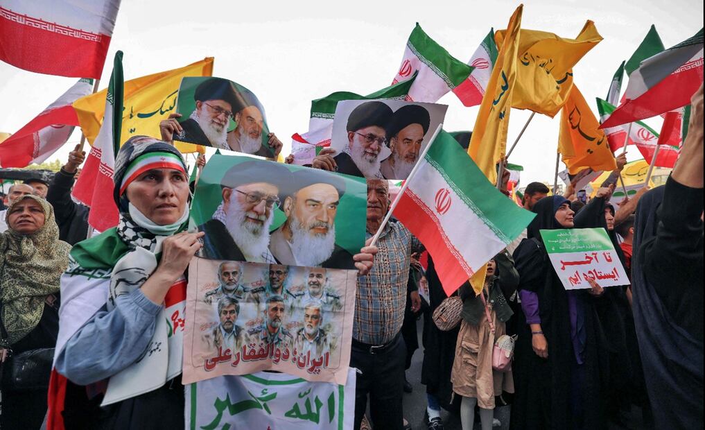 Una mujer iraní sostiene un cartel con los retratos del líder supremo iraní, el ayatolá Alí Jamenei y del difunto líder supremo, el ayatolá Ruhollah Jomeini, mientras la gente celebra en Teherán, el 24 de junio de 2025. Foto: AFP