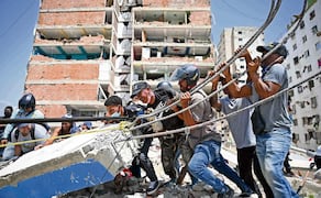 Voluntarios intentan retirar escombros mientras buscan cuerpos en Catia La Mar, La Guaira. Foto: Federico Parra / AFP