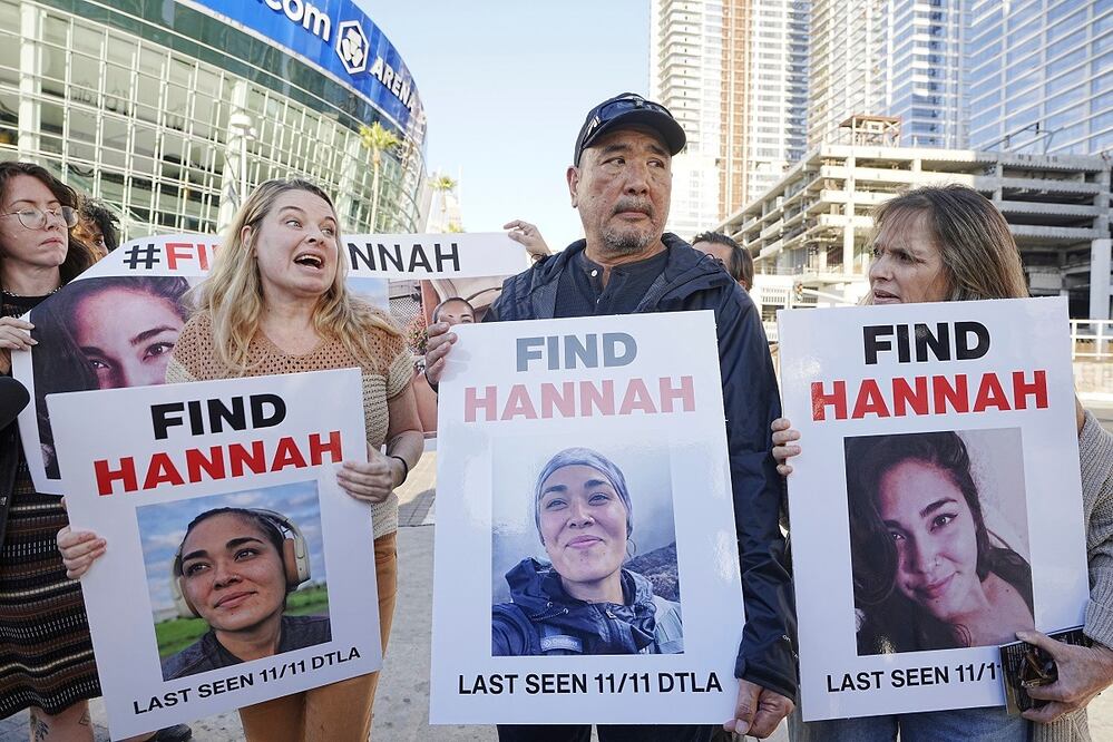 Ryan Kobayashi, en el centro, sostiene una foto de su hija desaparecida Hannah Kobayashi fuera Crypto.com Arena, jueves, 21 de noviembre 2024 en Los Ángeles. FOTO: DAMIAN DOVARGANES. AP