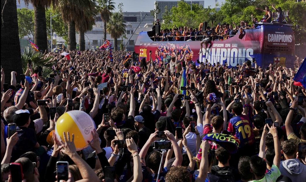 Miles de aficionados celebran junto con los jugadores del FC Barcelona la consecución del triplete nacional por las calles de la capital catalana, el viernes 16 de mayo de 2025. Foto: AP