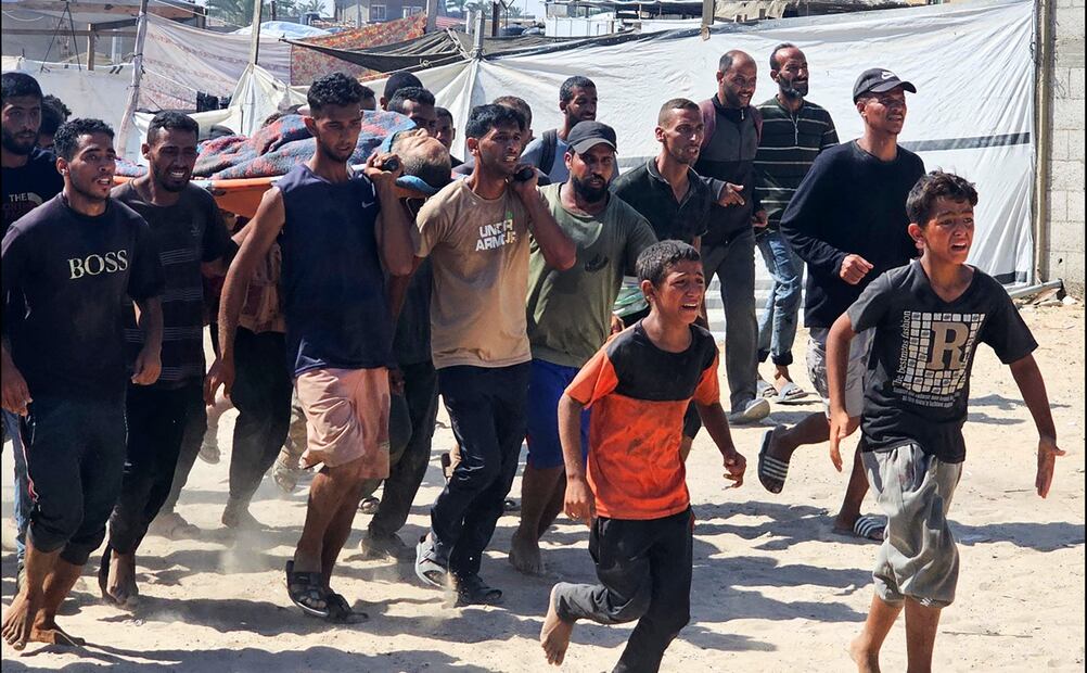 Hombres y niños palestinos llevan a una víctima de un ataque a una clínica de la Cruz Roja en Rafah, en la Franja de Gaza, tras recibir disparos mientras esperaban por paquetes de alimentos en un punto de distribución de la Fundación Humanitaria de Gaza (FGH), respaldada por Estados Unidos e Israel, el 12 de julio de 2025. Foto: AFP