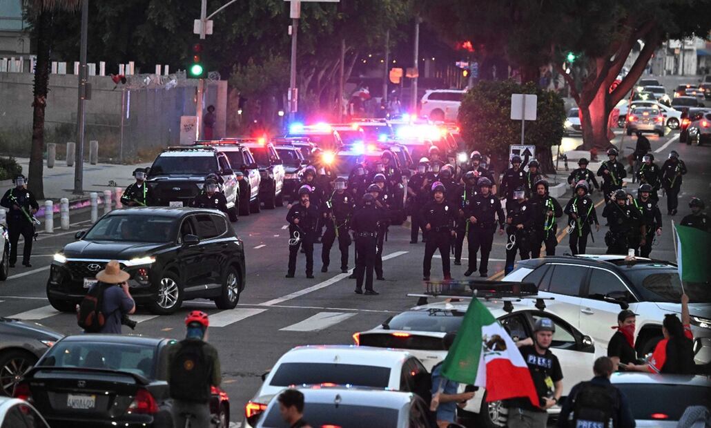 Agentes del Departamento de Policía de Los Ángeles se alinean en la calle Spring al entrar en vigor el toque de queda, tras cinco días de protestas en respuesta a las operaciones federales de inmigración en Los Ángeles, el 10 de junio de 2025. Foto: AFP