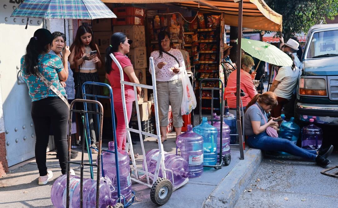 Acompañados de diablitos, bancos y sombrillas, vecinos del Pedregal de Santo Domingo, uno de los nueve barrios originarios de Coyoacán que enfrenta problemas de suministro, se forman cada miércoles para conseguir un botellón de 20 litros del programa Agua Bienestar. Foto: Gabriel Pano / EL UNIVERSAL