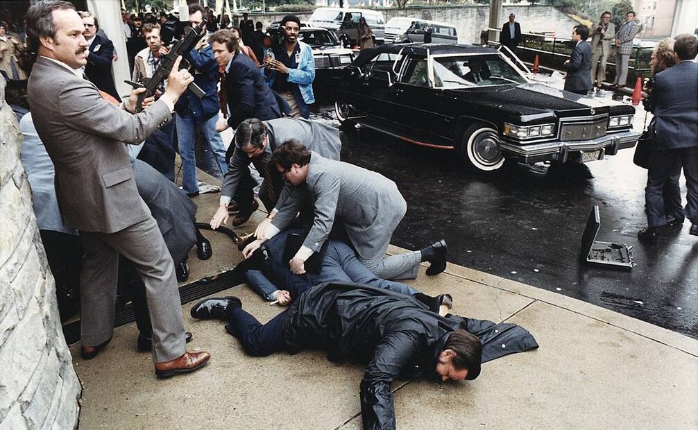 Dos de las personas que cayeron al suelo por sus heridas, y que se ven en esta foto, son el oficial Delahanty (centro, al frente) y James Brady, detrás de él. Wikimedia Commons.