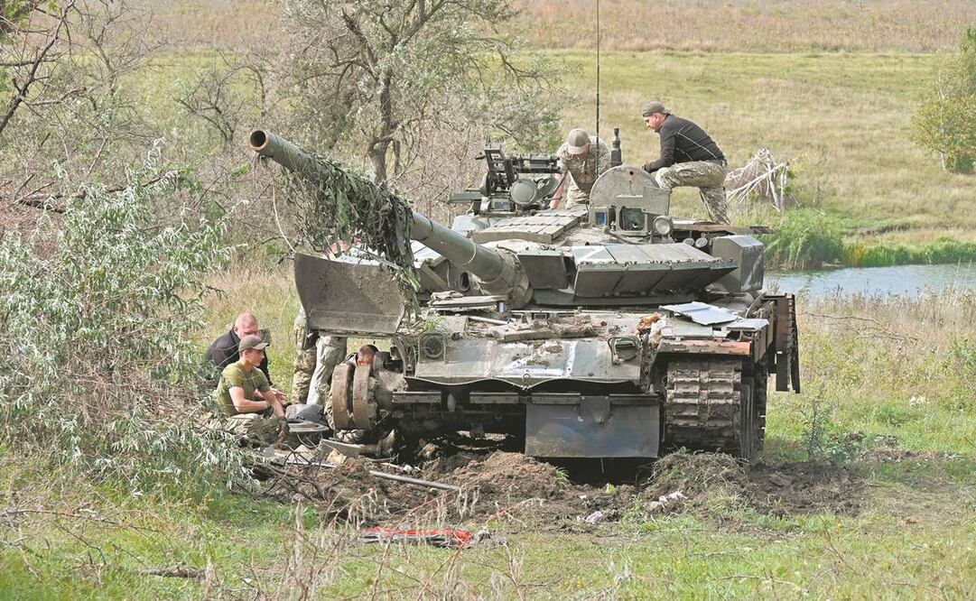 Militares ucranianos revisan un tanque abandonado por las tropas rusas durante su retirada en Kharkiv. Foto: Sergey Bobok/ AFP.