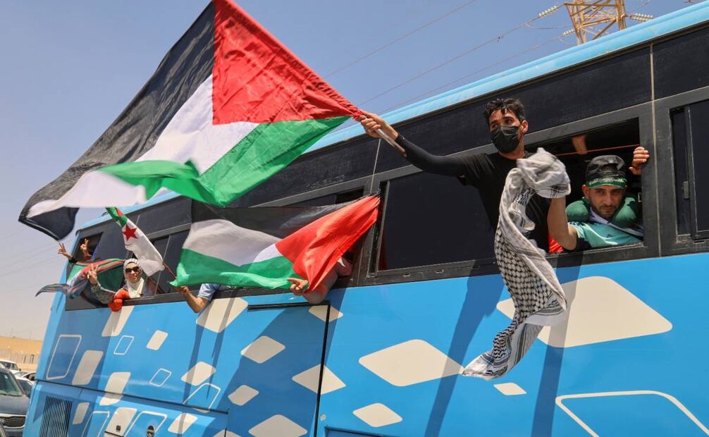 Miembros de una caravana humanitaria de al menos 1.500 personas, incluidos activistas y partidarios de Argelia y Túnez, ondean banderas palestinas desde un autobús mientras el grupo viaja hacia Gaza. Foto: AP Foto/Yousef Murad