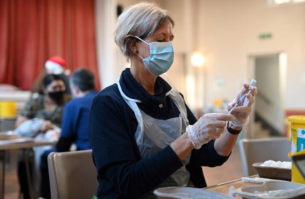Una mujer del personal sanitario prepara dosis de Pfizer para ser aplicada. Foto: AFP / Oli Scarff