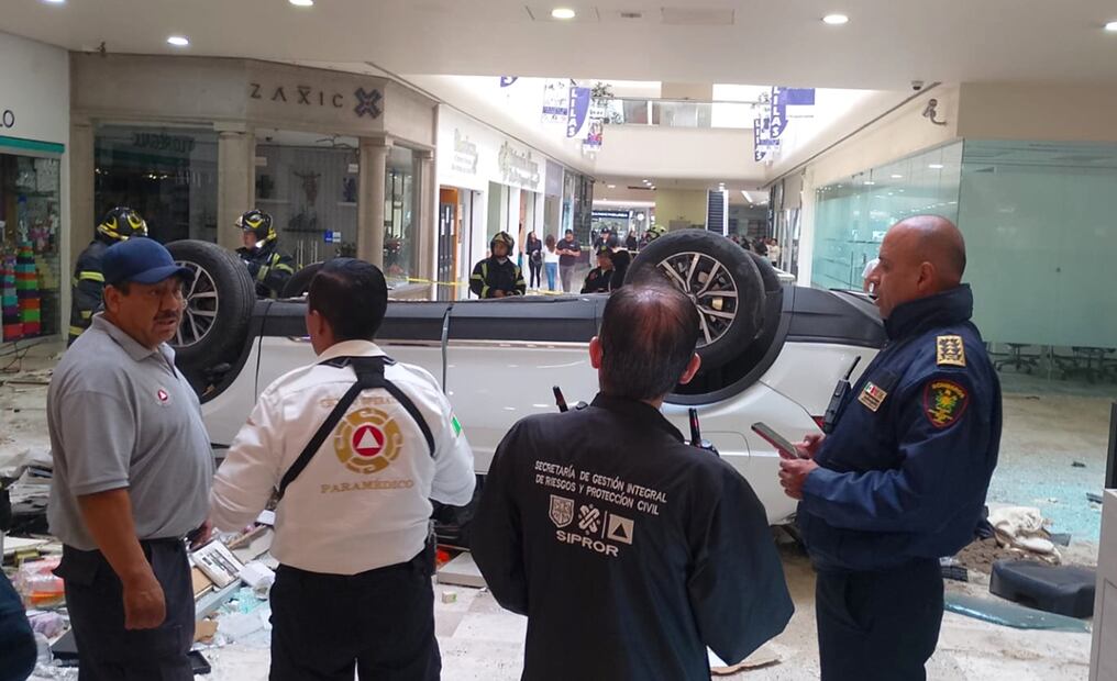 Un automóvil conducido por una mujer cayó desde un tercer nivel al interior de la Plaza Lilas, en la alcaldía Cuajimalpa, el sábado 24 de mayo de 2025. Foto: @SGIRPC_CDMX