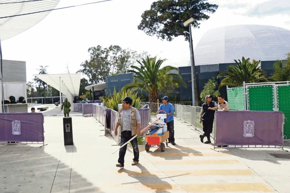 Trabajadores realizan labores de limpieza en las inmediaciones del recinto donde la panista Martha Érika Alonso asumirá el cargo de gobernadora de Puebla. (OMAR CONTRERAS. EL UNIVERSAL)