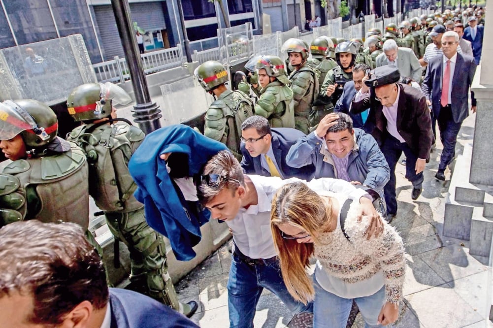 Miembros de la Guardia Nacional Bolivariana custodian el paso a diputados de la Asamblea Nacional, en Caracas (MIGUEL GUTIÉRREZ. EFE)
