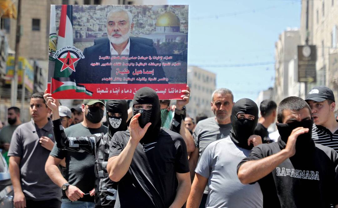Hombres palestinos con una pancarta de la imagen del líder de Hamás, Ismail Haniyeh. Foto: AFP