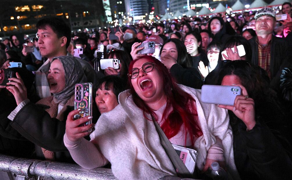 Los fans de BTS reaccionan mientras ven el concierto de regreso del grupo de K-pop BTS en una pantalla en el recinto de Seúl. 
Foto de Jung Yeon-je / AFP