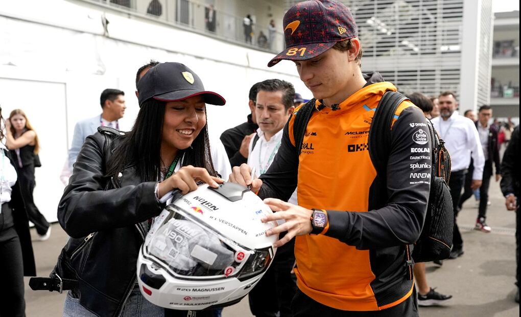 El piloto de McLaren, Oscar Piastri, de Australia, firma un casco cuando llega a la primera práctica libre. Foto: AFP