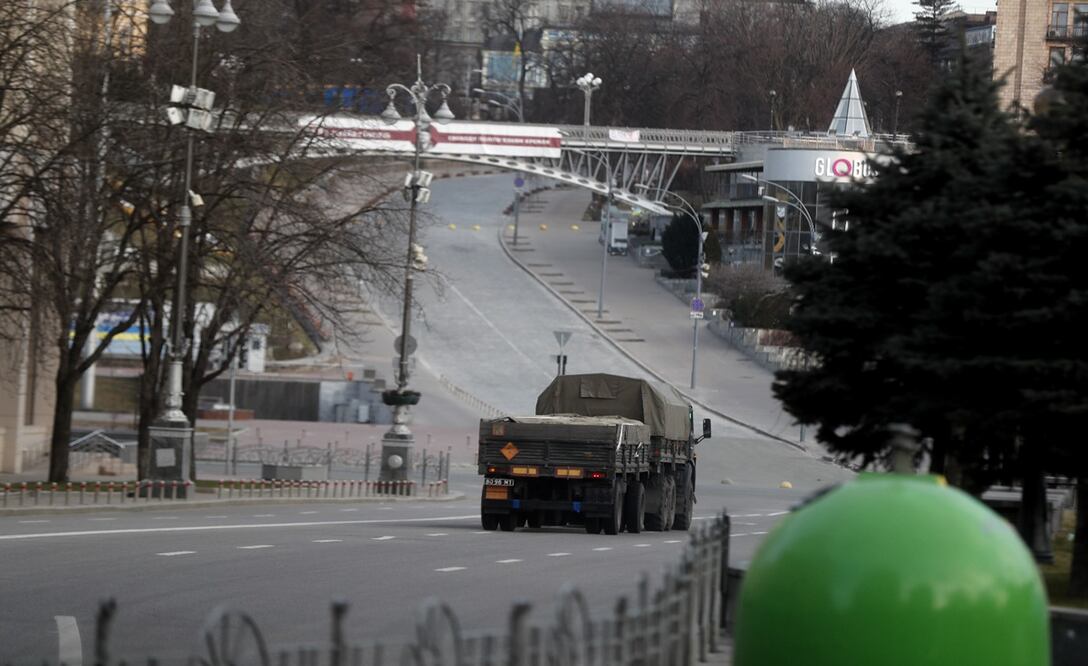 Imagen de un vehículo militar que cruza a un lado de la Plaza de la Independencia vacía en la ciudad de Kiev