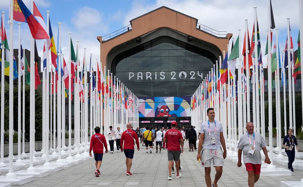 La gente camina frente a la cantina de la Villa Olímpica, en los Juegos Olímpicos de Verano de 2024. Foto AP/Michel Euler