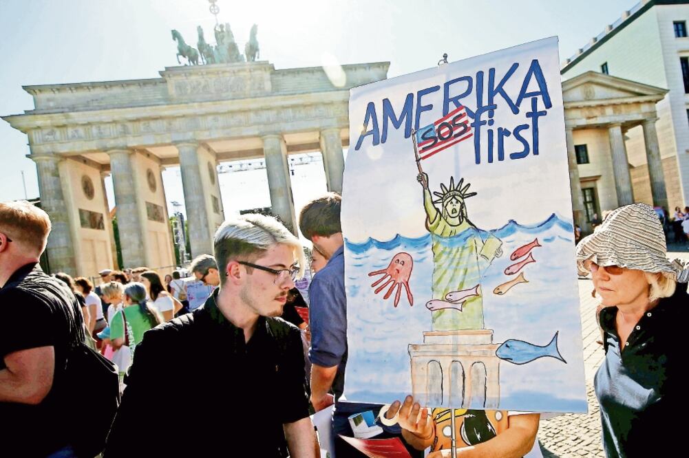 Manifestantes salieron ayer a protestar junto a la Puerta de Brandeburgo, a un lado de la embajada de Estados Unidos en Alemania, contra la salida del gobierno estadounidense del Acuerdo de París. FOTO: FABRIZIO BENSCH. REUTERS