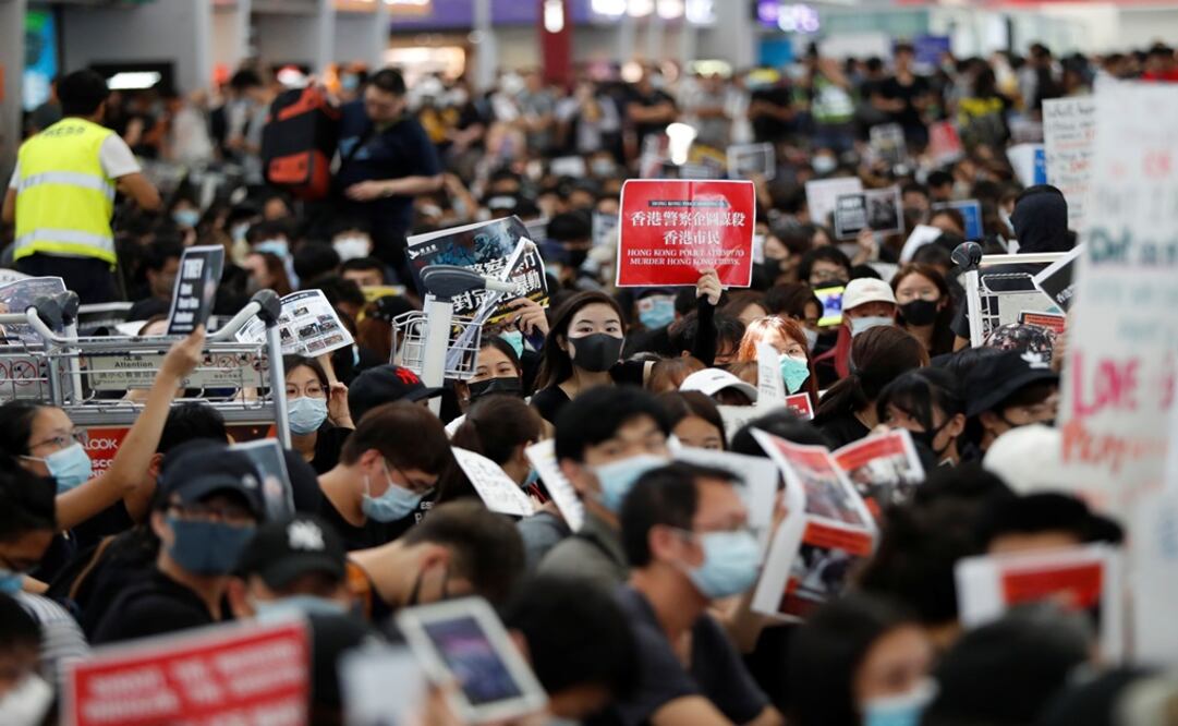 Anti-government protesters sit on the floor in front of security gates during a demonstration at Hong Kong Airport - Photo: Issei Kato/REUTERS