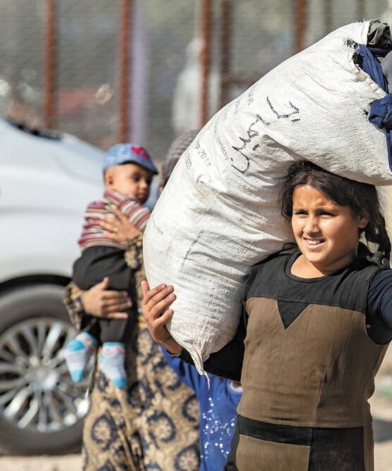 Una mujer huye de la zona de batalla entre los turcos y los kurdos, en Tal Tamr. DELIL SOULEIMAN. AFP