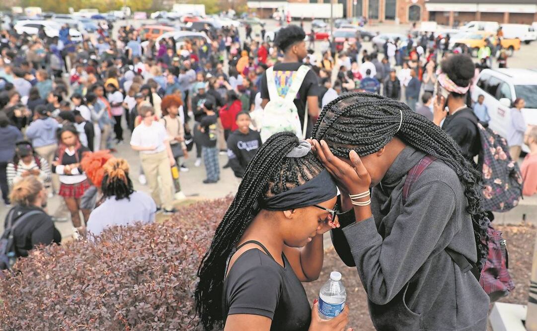 Estudiantes se refugiaron en un estacionamiento, cerca de la Escuela Secundaria Central de Artes Visuales y Escénicas, después del tiroteo. Foto: AP.