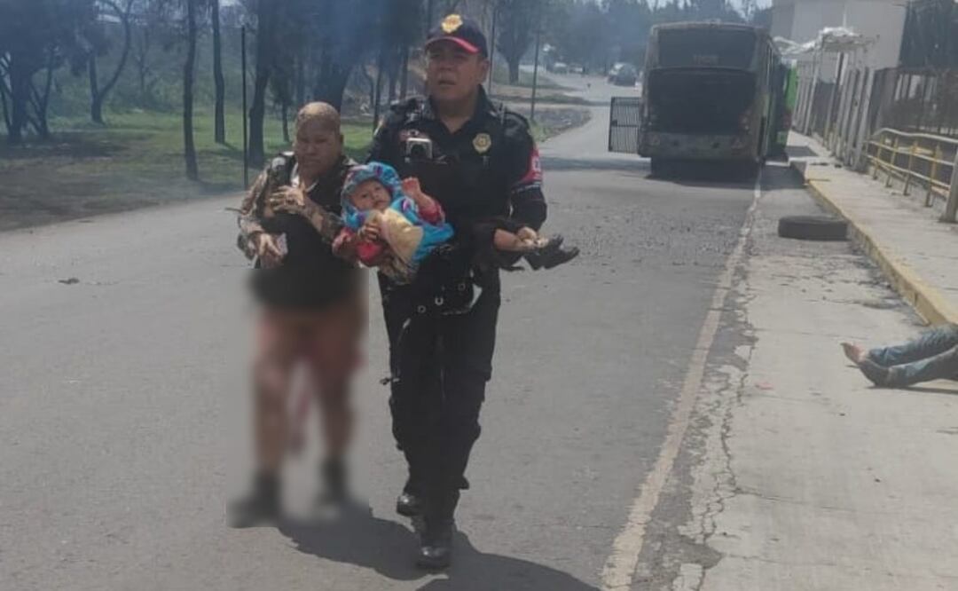 Mujer con quemaduras camina sobre el asfalto junto a policía que carga a bebé tras explosión de pipa de gas en Puente de la Concordia, Iztapalapa (10/09/2025). Foto: Especial
