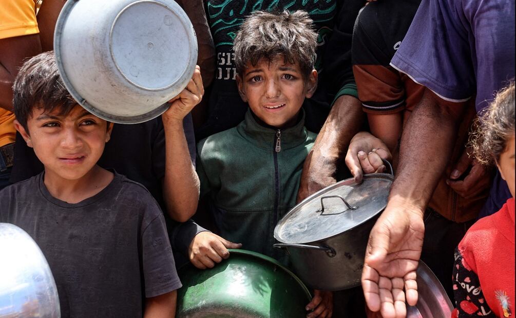 Niños esperan ansiosos frente a un camión de distribución de comida cerca del puerto de la ciudad de Gaza, el 22 de mayo de 2025. Foto: AFP