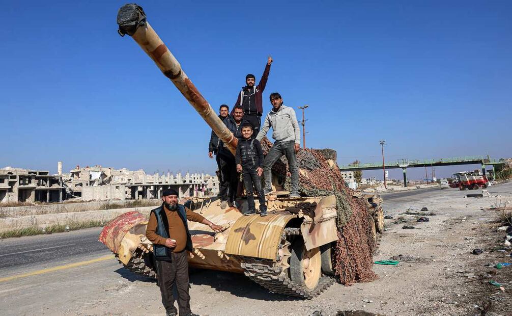 Un grupo de sirios se encuentran en la parte trasera de un tanque en la Autopista Internacional Alepo-Damasco M5, capturada por la oposición siria, Siria, 03 de diciembre de 2024. Las fuerzas de oposición sirias, lideradas por el grupo militante islamista Hayat Tahrir al-Sham (HTS), lanzaron una ofensiva el 27 de noviembre, tomando grandes partes de Alepo, la segunda ciudad más grande de Siria. La ofensiva provocó contraataques por parte de las fuerzas del régimen sirio, así como bombardeos aéreos rusos y sirios en áreas controladas por la oposición. Foto: EFE