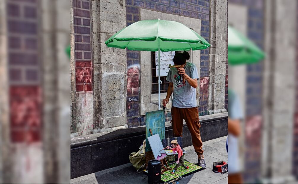 Morionet toma uno de los pinceles y cadenciosamente, al ritmo de la música, plasma una obra de arte que es admirada por los transeúntes. Foto: Paola Reyes / EL UNIVERSAL