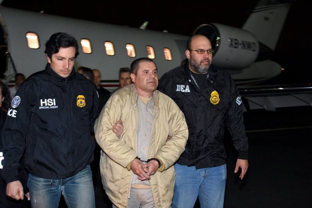 In this photo provided U.S. law enforcement, authorities escort Joaquin "El Chapo" Guzman, center, from a plane to a waiting caravan of SUVs at Long Island MacArthur Airport on Thursday, Jan. 19, 2017, in Ronkonkoma, N.Y. (U.S. law enforcement via AP)