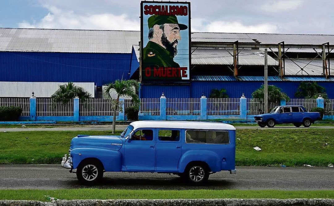 Autos antiguos, junto a una valla publicitaria en La Habana, el lunes pasado. Foto by Yamil Lage / AFP