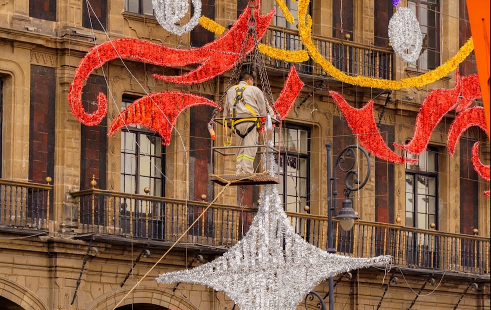 Personal de obras y Servicios alista el alumbrado decorativo para las fiestas decembrinas y fin de año; mientras, comerciantes acomodan sus puestos y productos para ofrecerlos en la romería de la plancha del Zócalo capitalino, el lunes 8 de diciembre de 2025. Foto: Osmar Alvarado/EL UNIVERSAL