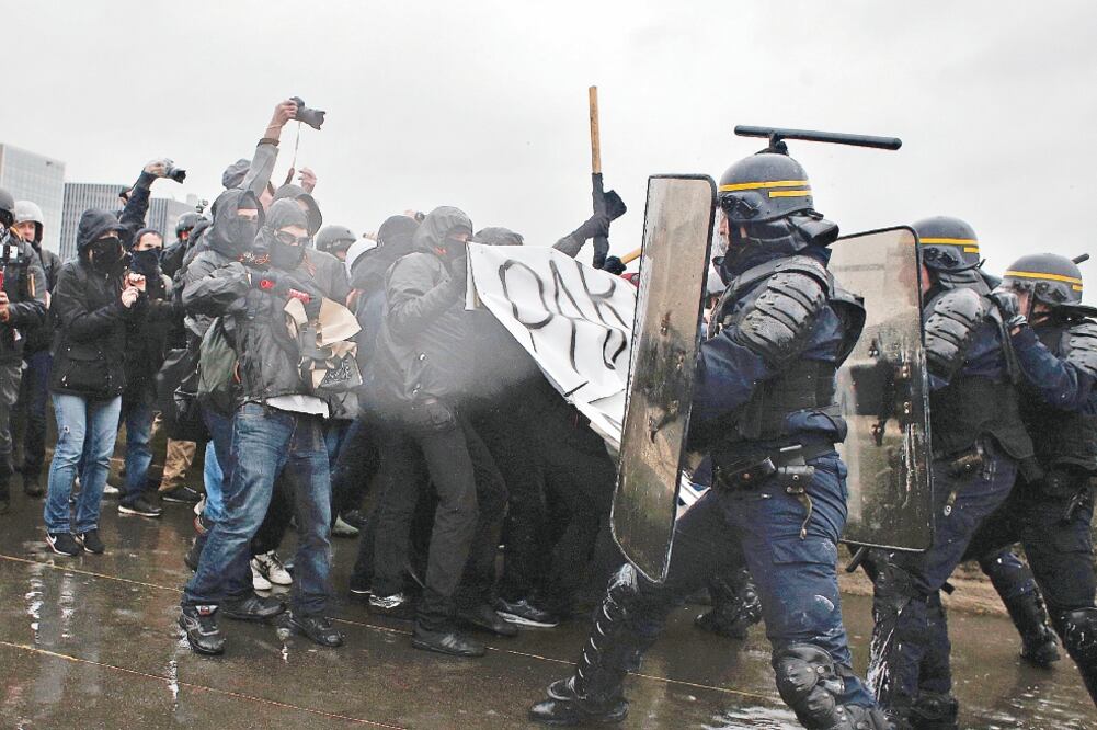 Manifestantes se enfrentan a policías antimotines, durante las protestas de ayer en París que obligaron al cierre de la Torre Eiffel y el Palacio de Versalles (THIBAULT CAMUS. AP)